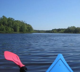 Kayak rip and paddle, Concord River with blue sky and green trees