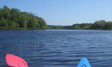 Kayak rip and paddle, Concord River with blue sky and green trees