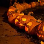 stock image of jackolanterns at night, lighting a paved walkway