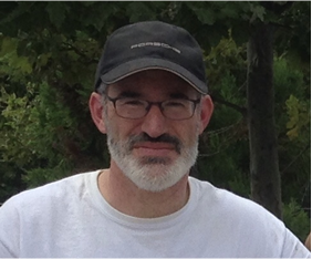 David Braslau, man in hat smiling with trees behind