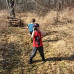 one young boy explores path of yellow grass another holds binoculars over his eyes