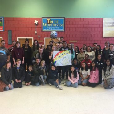 group of teens and organizations attending the EYC - one stduent holds a earth ball, and a sign reads "Welcome to the 2019 EYC"