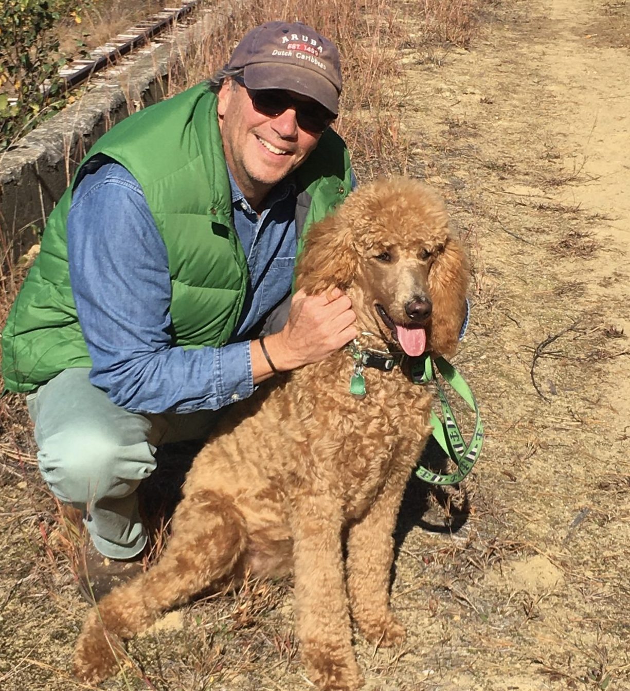 Stephen Conant posing with a tan poodle