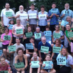 group of 2019 volunteers holding up signs of their efforts