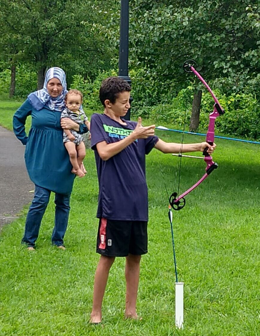 a boy does archery at family outdoors day