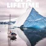 Film poster for 'Of a Lifetime' featuring a boat near an iceberg in calm waters, directed by Jerome Tanon, produced by The North Face.